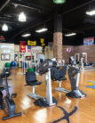 A gym with many different types of exercise equipment.