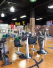 A gym with many different machines on the floor.